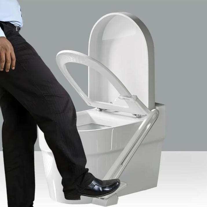 A Person is Pressing Pedal Type Toilet Lid Lifter Attached On The Toilet.