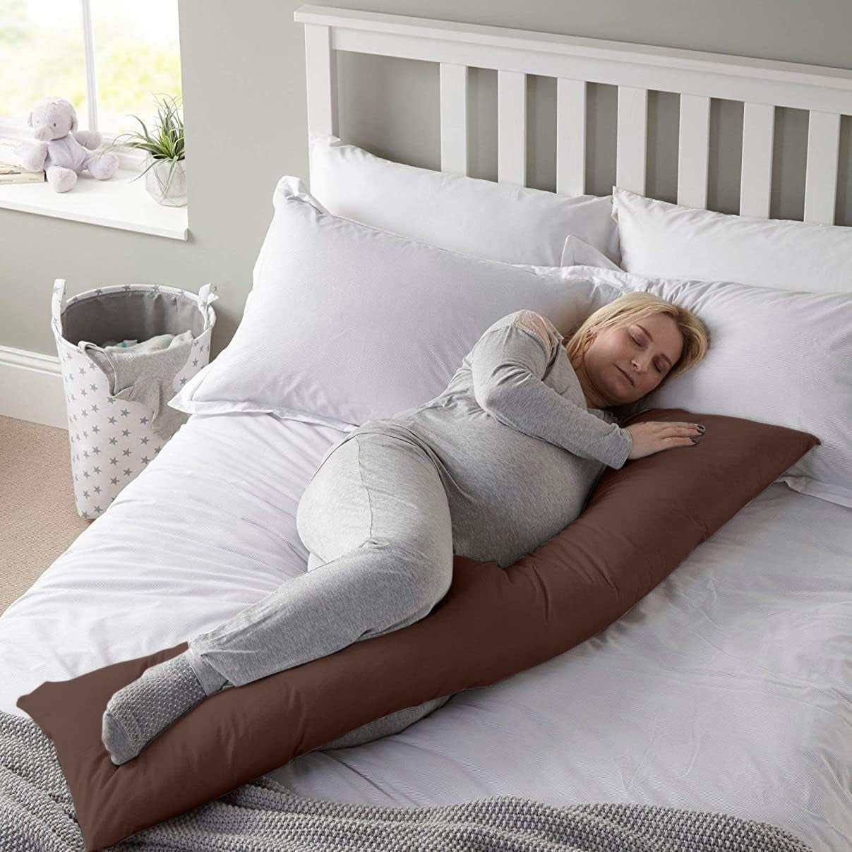 A Pregnant Woman is Sleeping with the Aid Of Body Pillow.