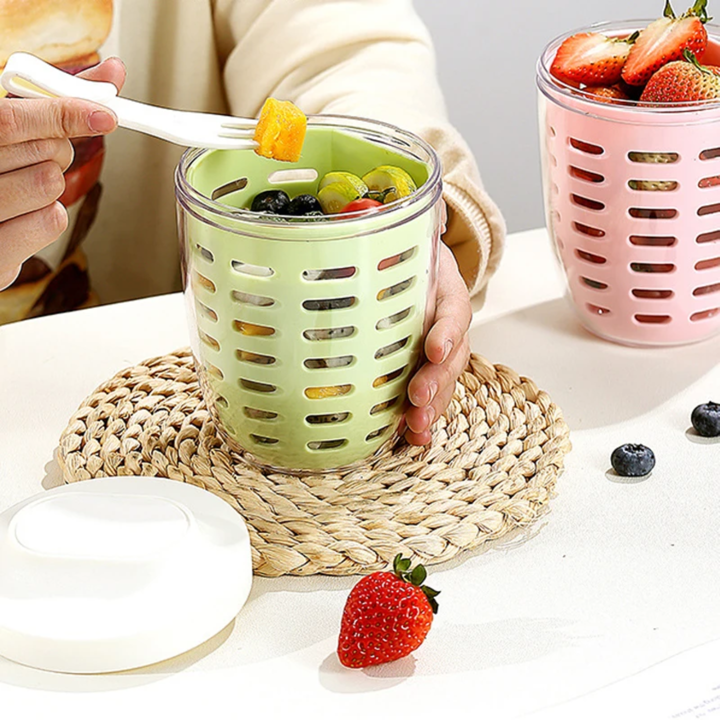A Person is Eating From Drainable Fruit Storage Cup.