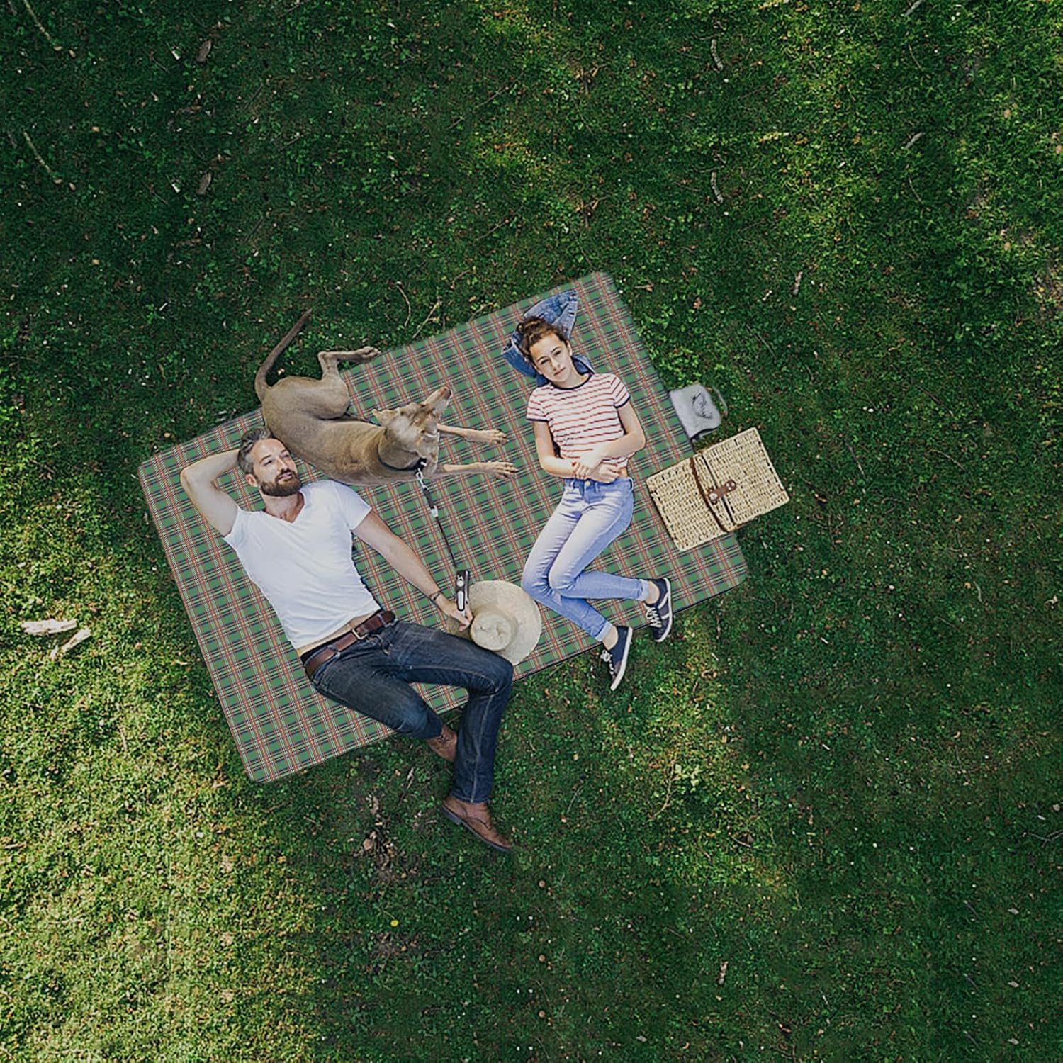 A couple with a dog lying on a Foldable Waterproof Picnic Mat in a park