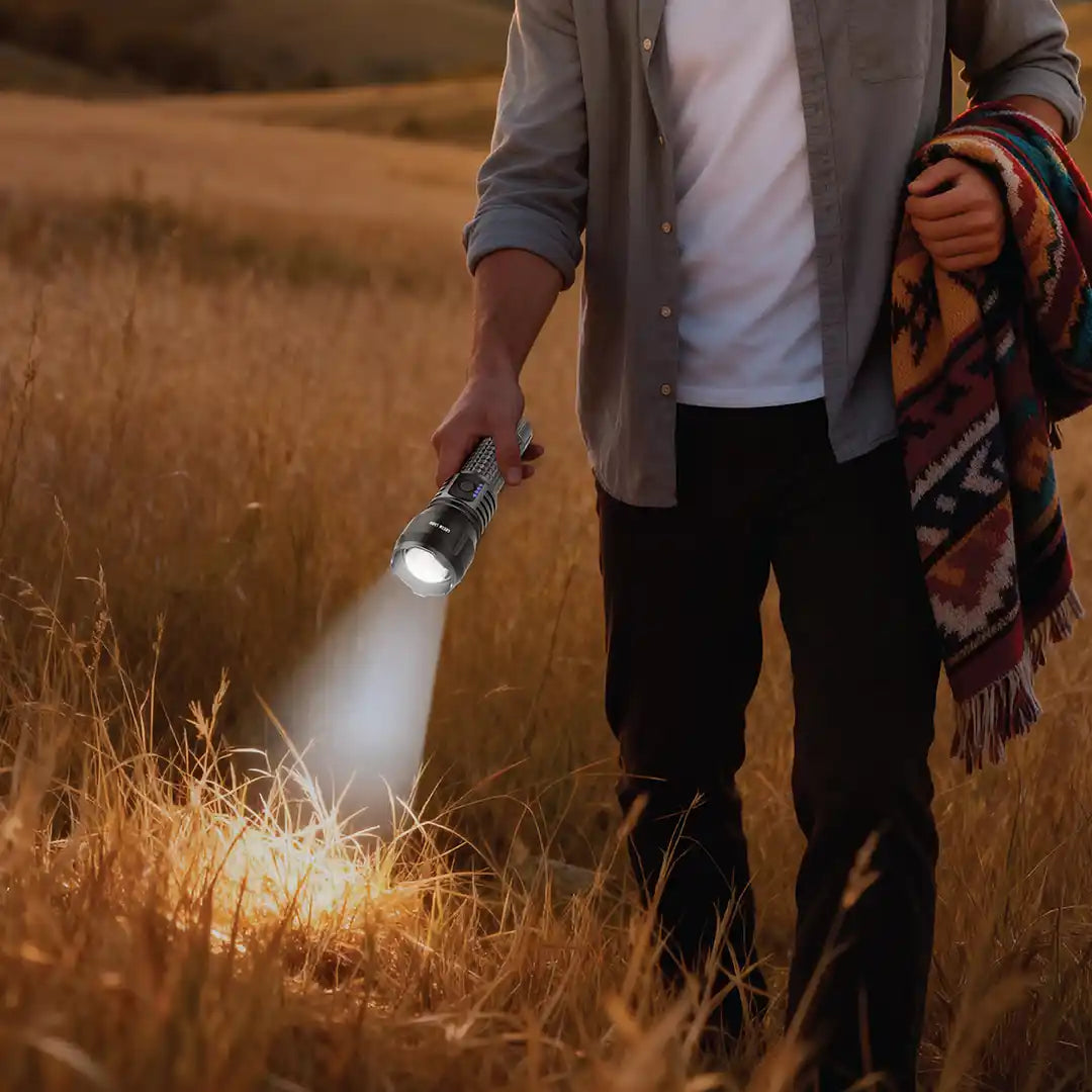 Person holding a Green Lion Hunter Portable LED Torch flash in a field with a blanket over their shoulder