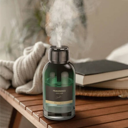 Green Lion Jumbo Fragrance Diffuser emitting steam on a wooden surface with books and a blanket in the background