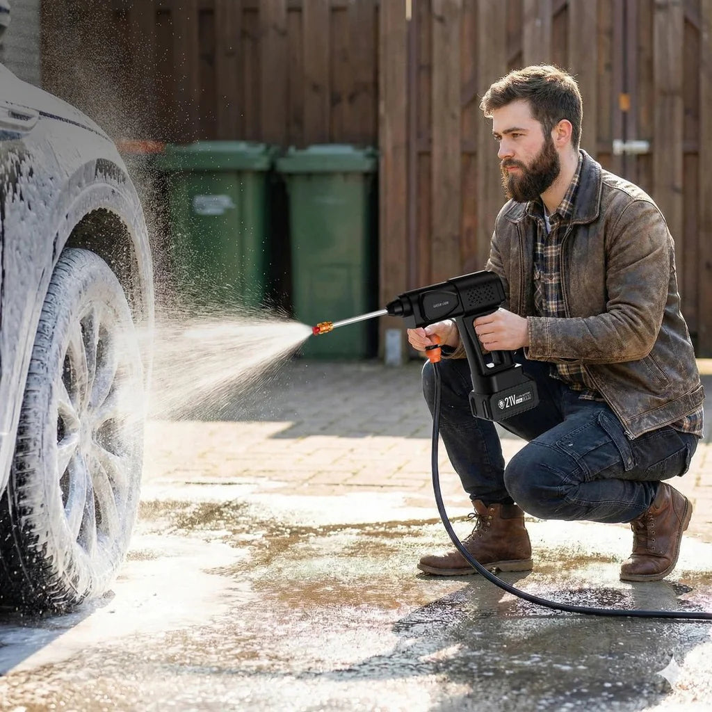 A man using a Green Lion 21V Cordless Pressure Wash Gun to clean a car tire outdoors.