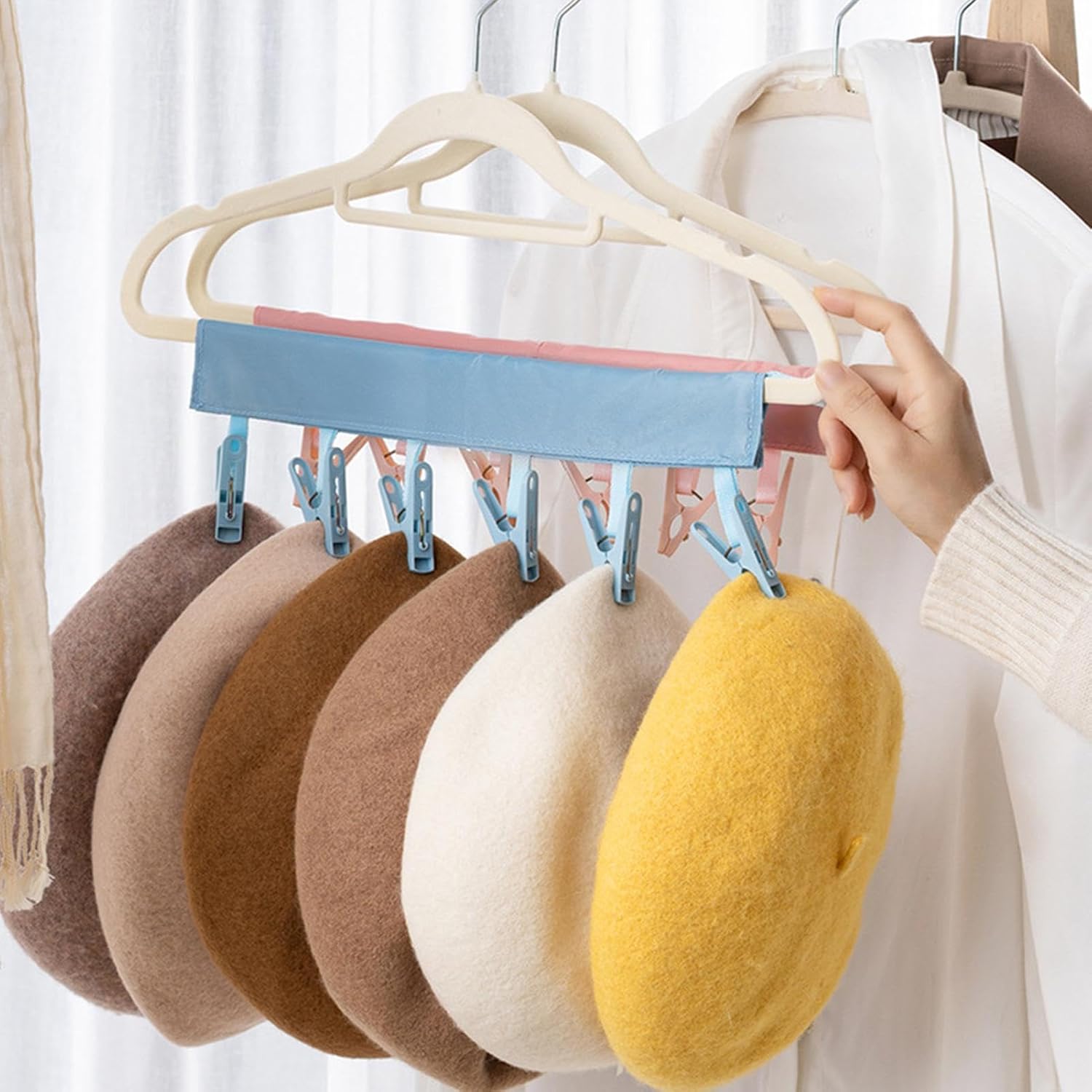 Multi-clip hanger holding wool berets, perfect for organized storage.