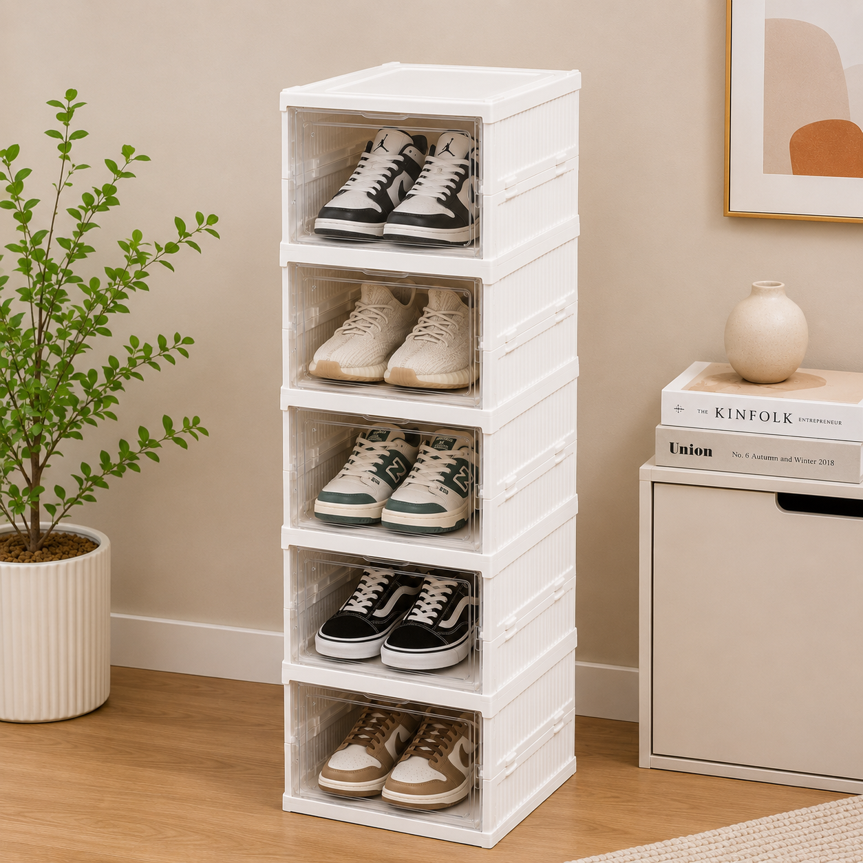 White shoe rack with shoes on a wooden floor next to a plant and books.