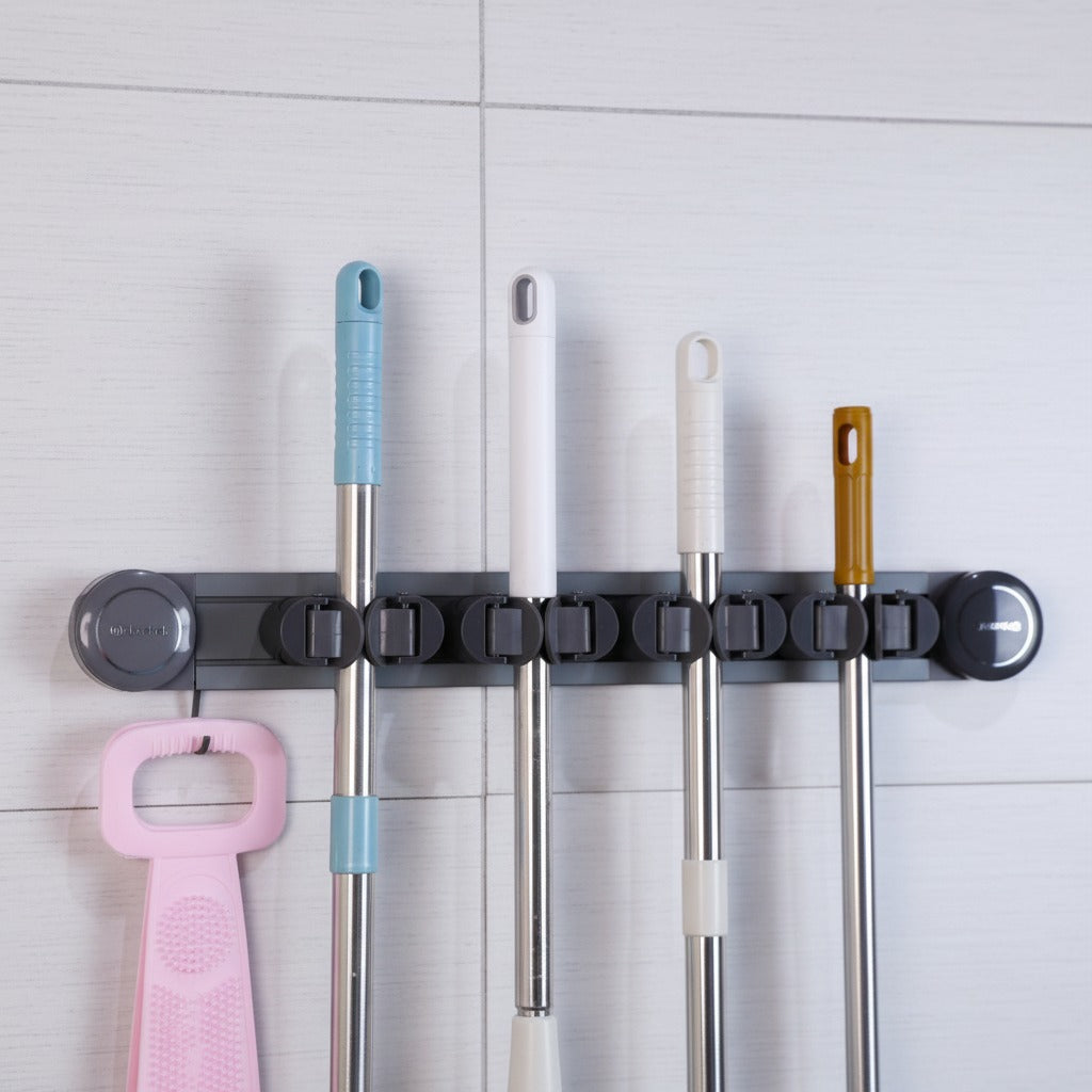 Mops and Brooms are Organized in a Wall Mounted Mop Holder.