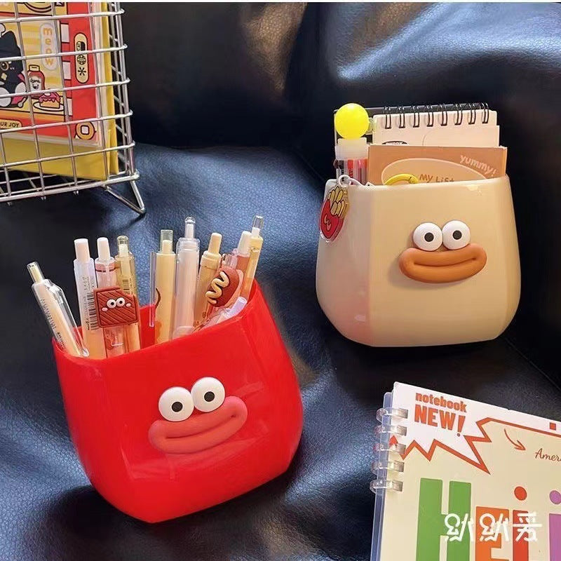 Two Cute cartoon-style desk organizers with smiling faces, used to hold pens, stationery, and small items, adding a fun and playful touch to any workspace.