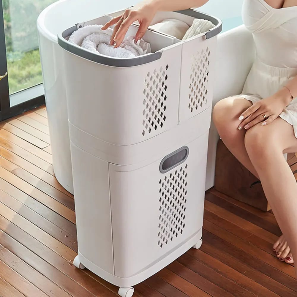 A woman drops a towel into the laundry basket