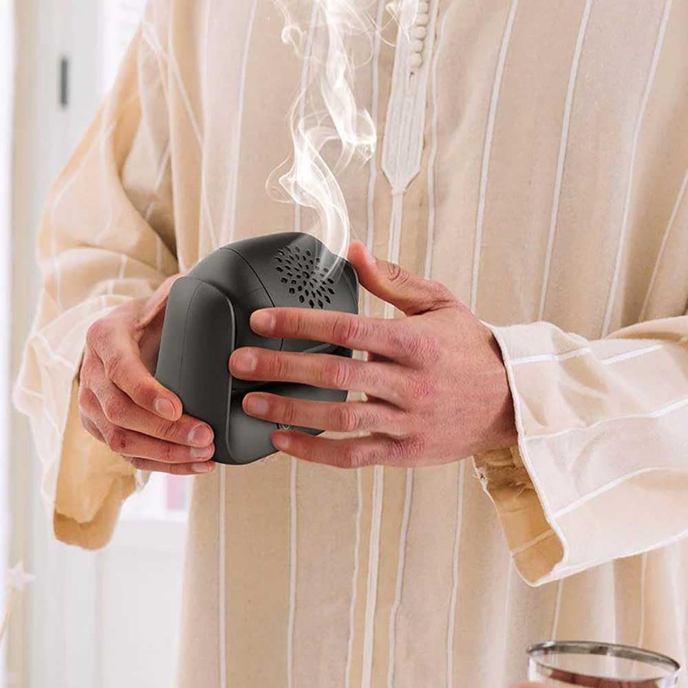 A Person is Holding Rotational Electric Incense Burner.