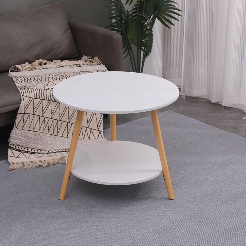 A round white side table is placed on a rug , cozy living room