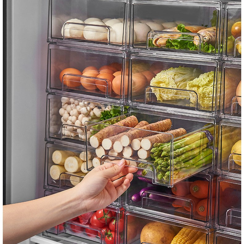 A person retrieves vegetables from a refrigerator drawer, utilizing a specialized storage box for efficient organization