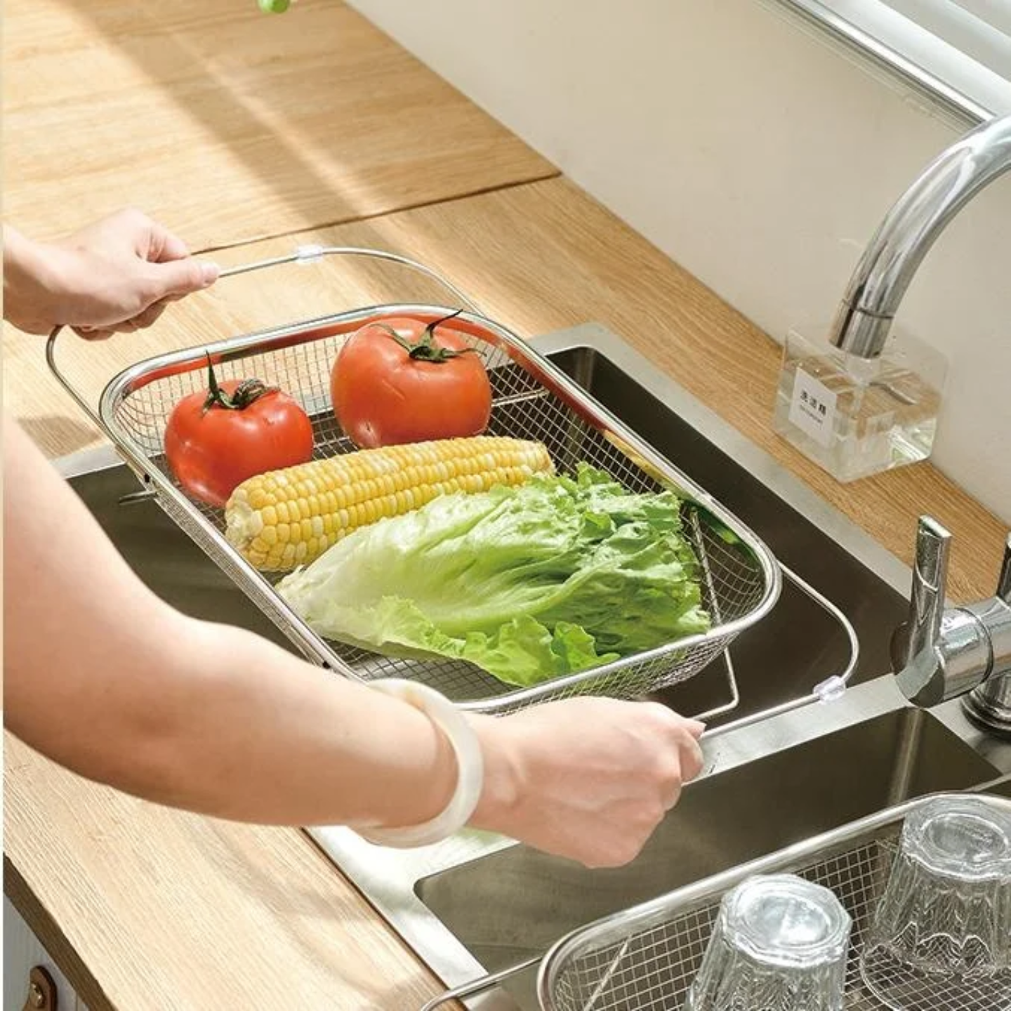 A Person is Draining Vegetables Using Sink Drain Basket Colander.