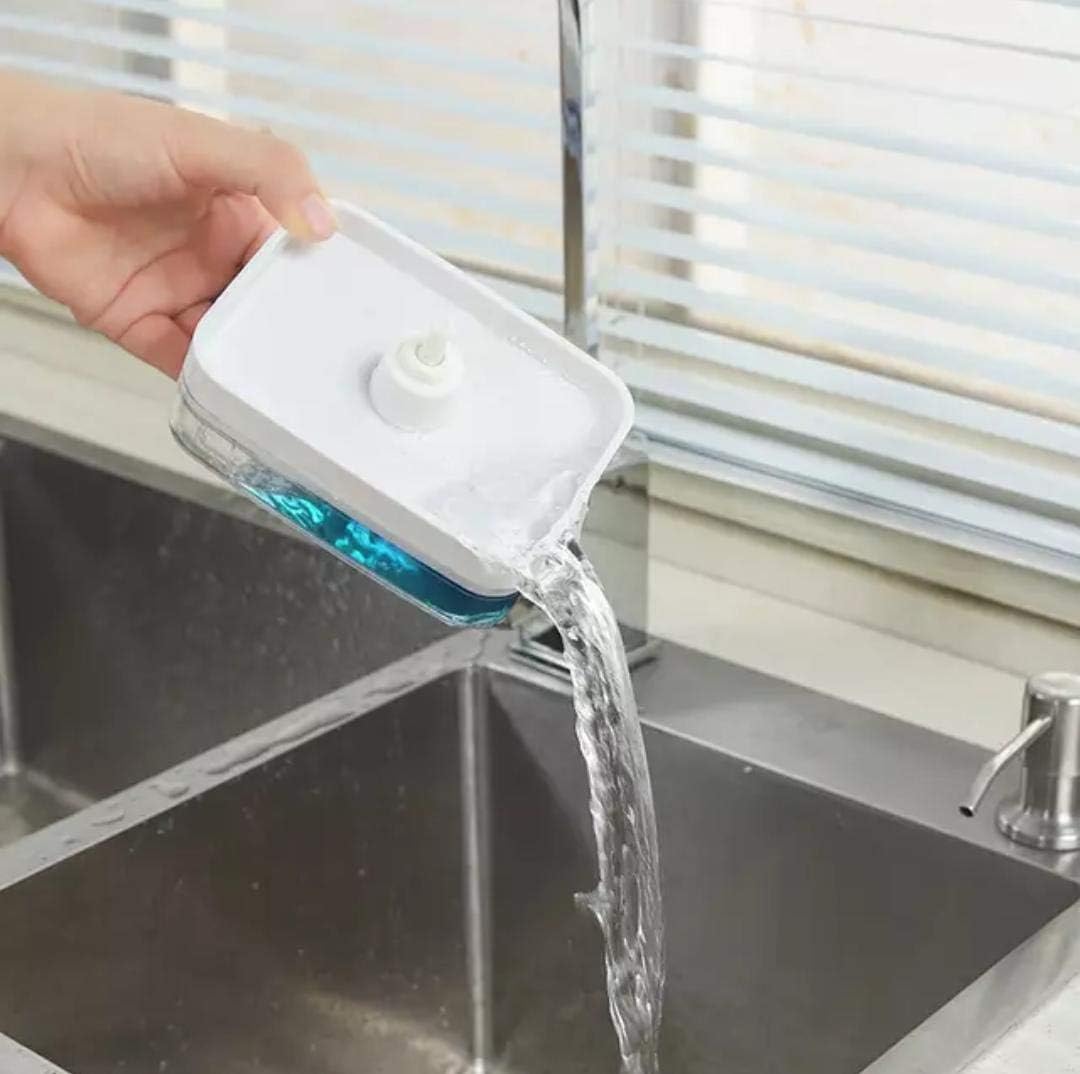 A compact soap dispenser with a built-in sponge tray, shown being tilted to pour out excess water from the reservoir, highlighting its easy-drain design for keeping the sponge clean and dry.