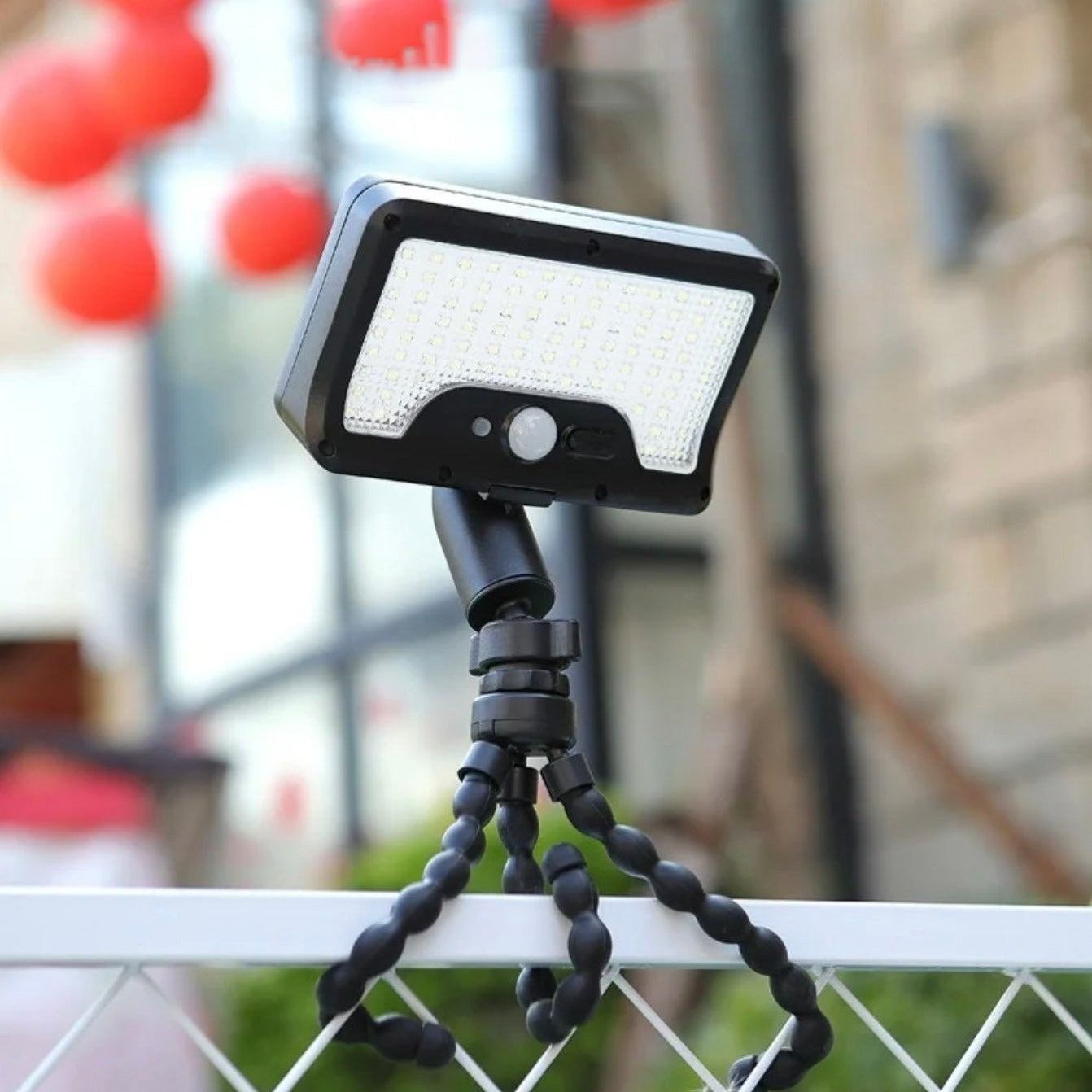 Solar Motion Sensor Light is attached on a fence.