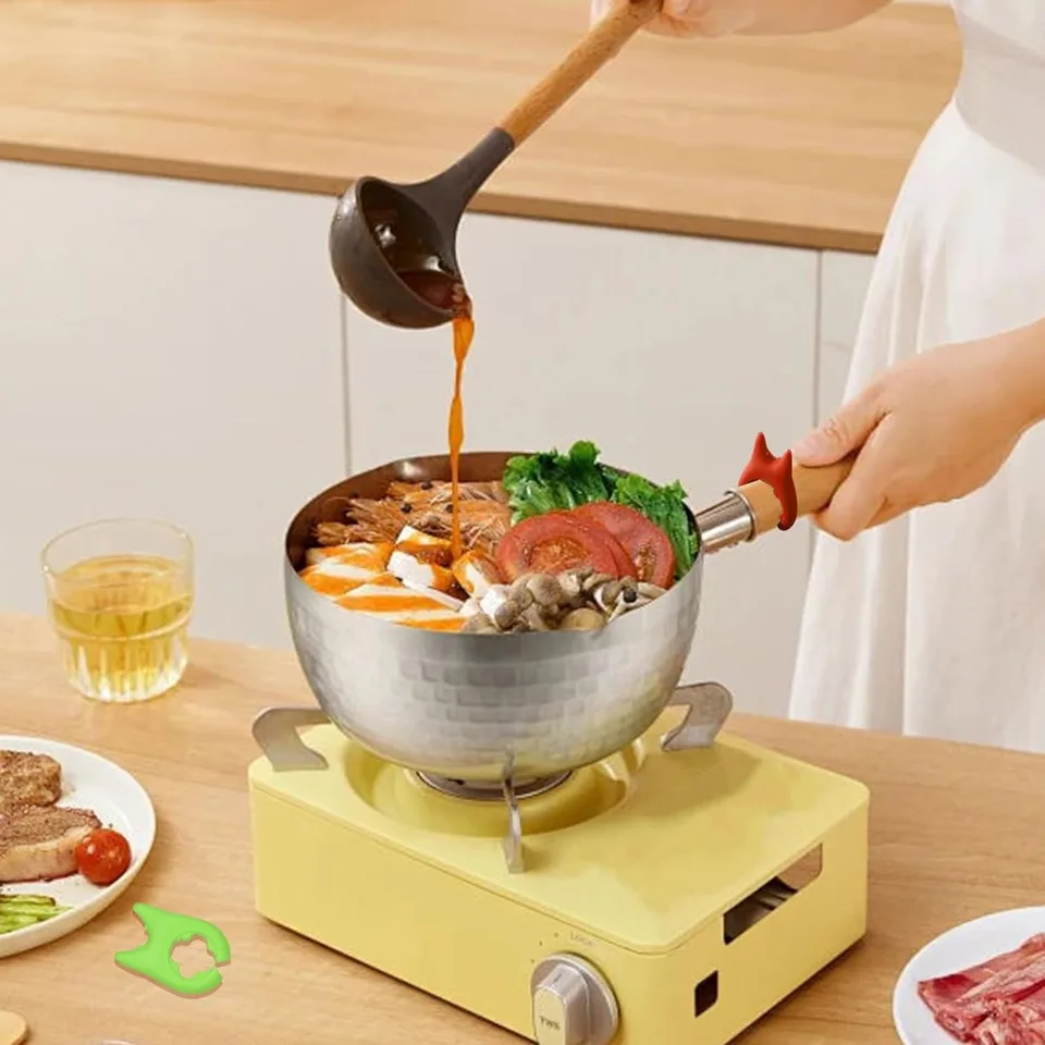 A Person is Cooking By Placing A Spoon Rest On the Handle Of Pan.