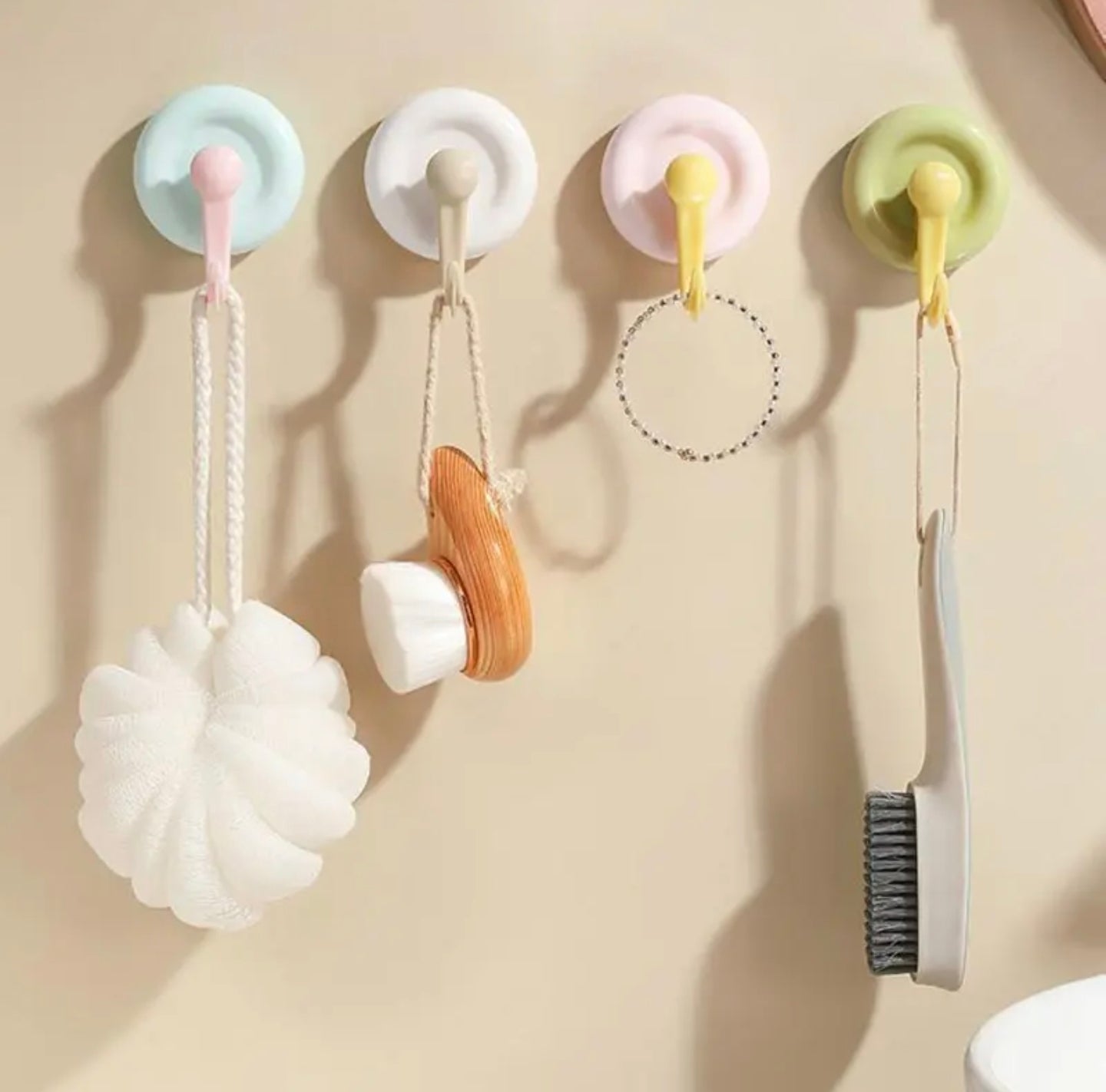 Colorful Strong Suction Cup Wall Hooks with various small items on a beige background