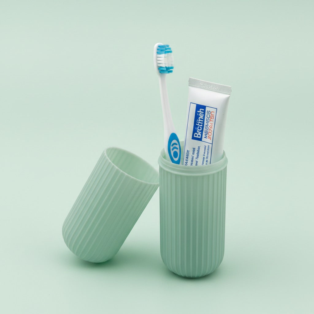 Green toothbrush holder with a toothbrush and tube of toothpaste on a light green background