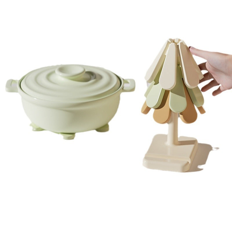 A Pot is Placed on a Tree Coaster Set and A Person is Taking from Tree Coaster Set.