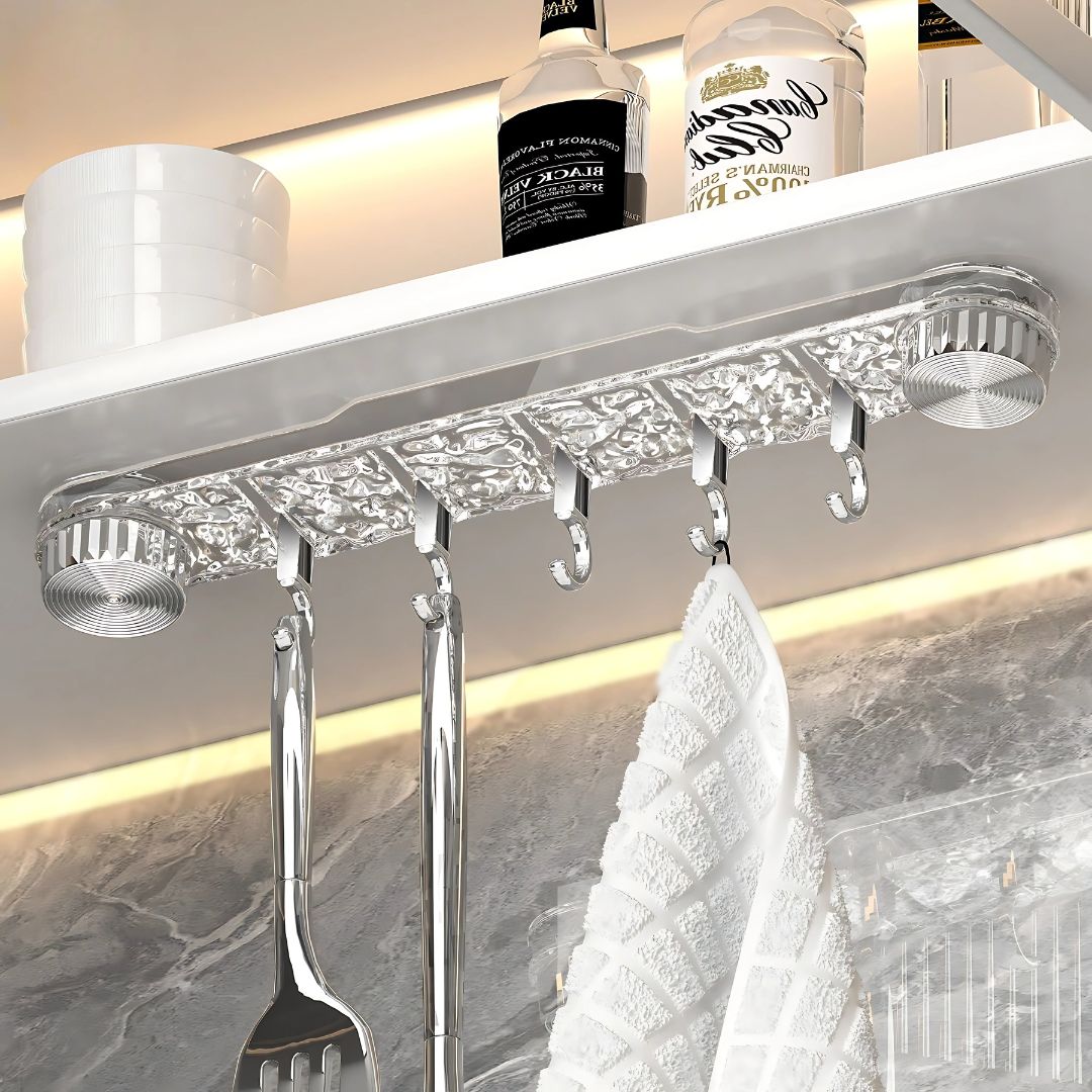 A Wall Mounted Suction Hook Holder is Fixed Under Kitchen Rack Holding Spoons and Towel.