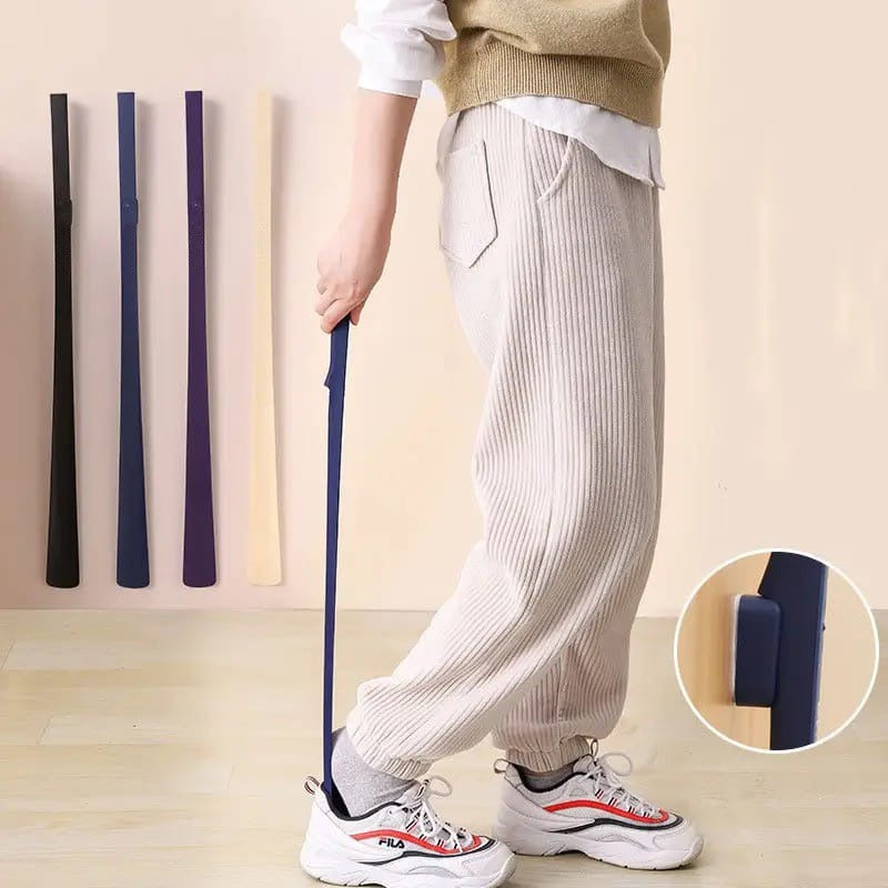 A Person is Wearing Shoe Using Long Handle Shoe Horn.