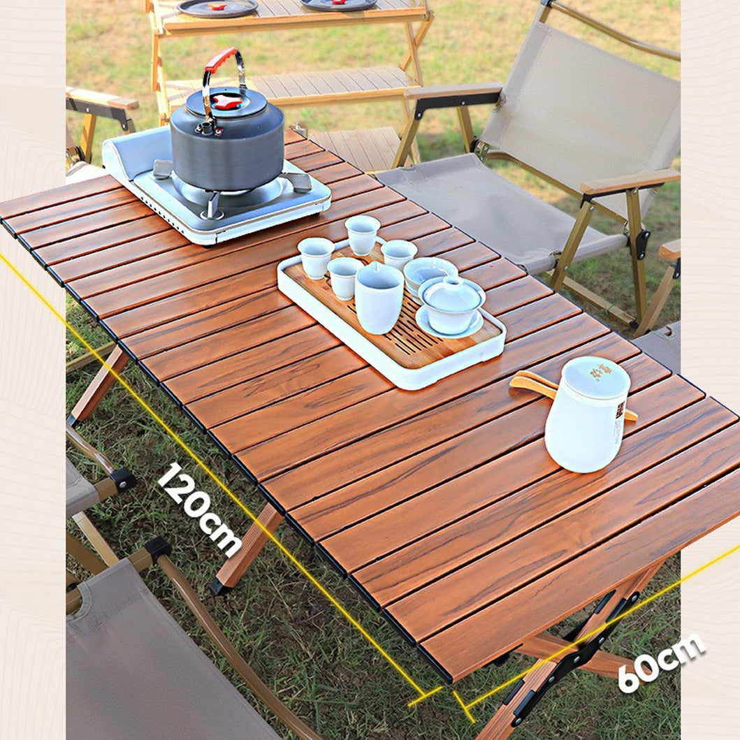 Outdoor Portable Camping Table with gas stove and tea pot set placed on top of it situated in a park and being used for picnic