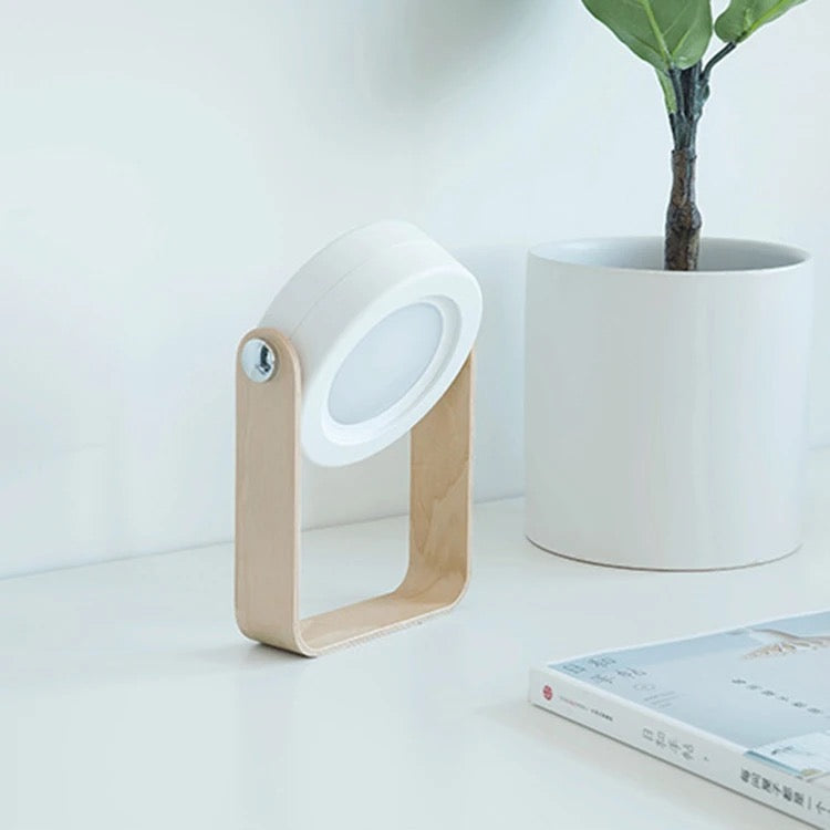 Retractable Table Lamp with USB Rechargeable placed on a table next to a book