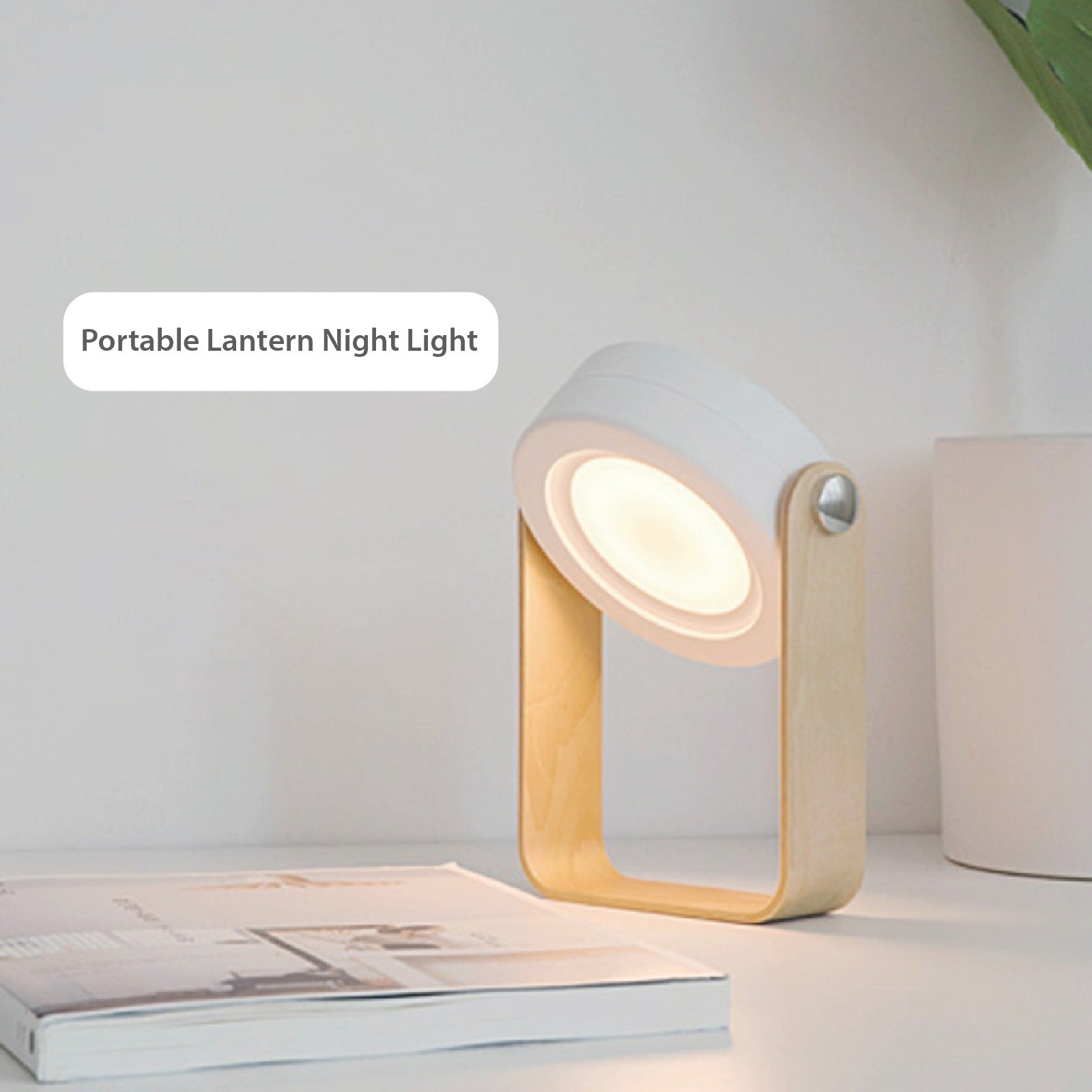 Retractable Table Lamp with USB Rechargeable, placed on a table next to a book