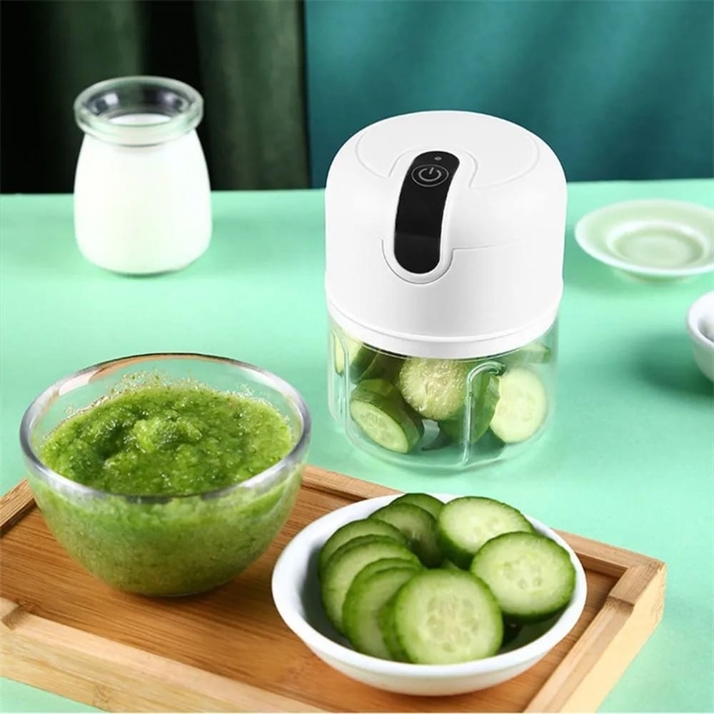 Mini Electric Chopper Food Processor placed on the table next to ingredients in bowls