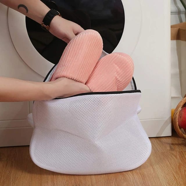 someone putting shoes into the reusable shoes washing laundry bag for washing shoes with washing machine