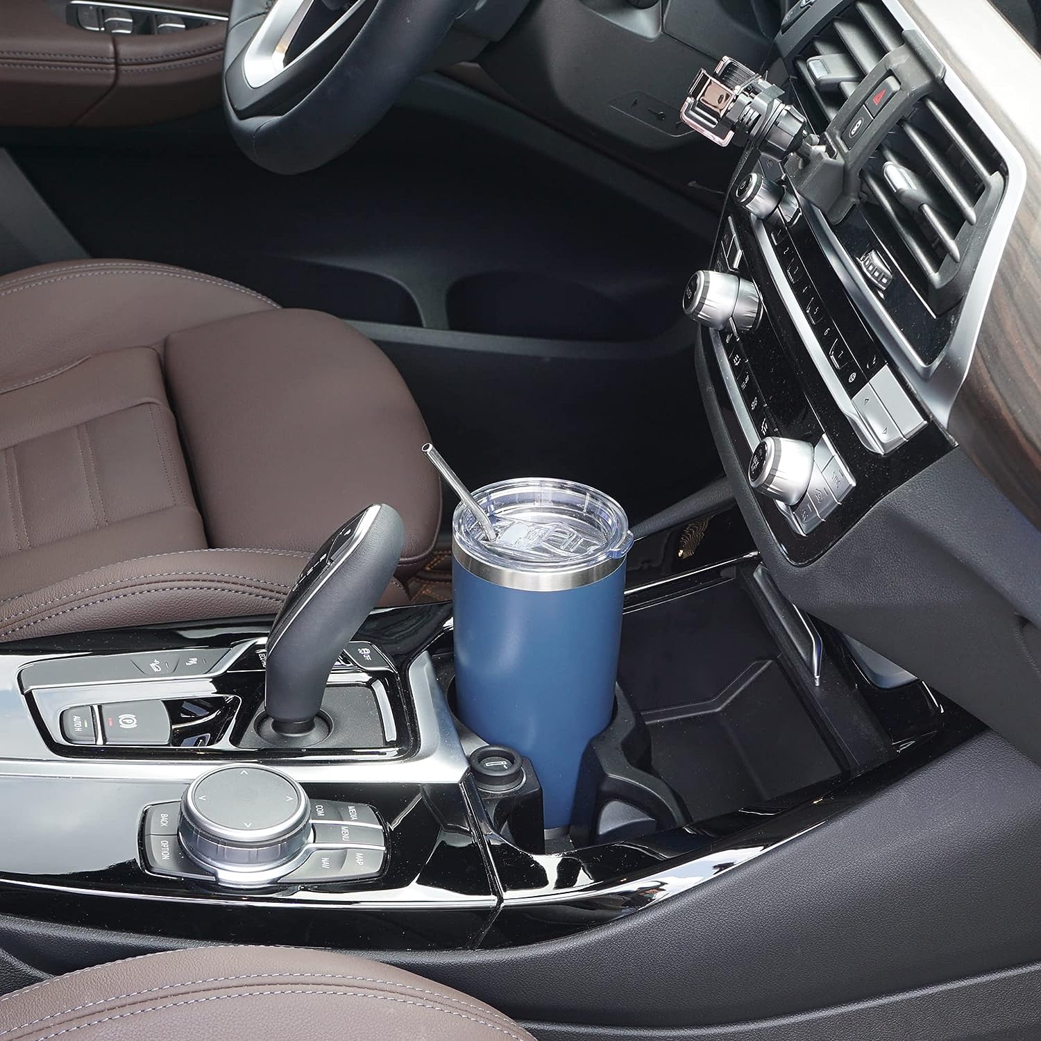 silver thermal travel mug holded up in a driving car