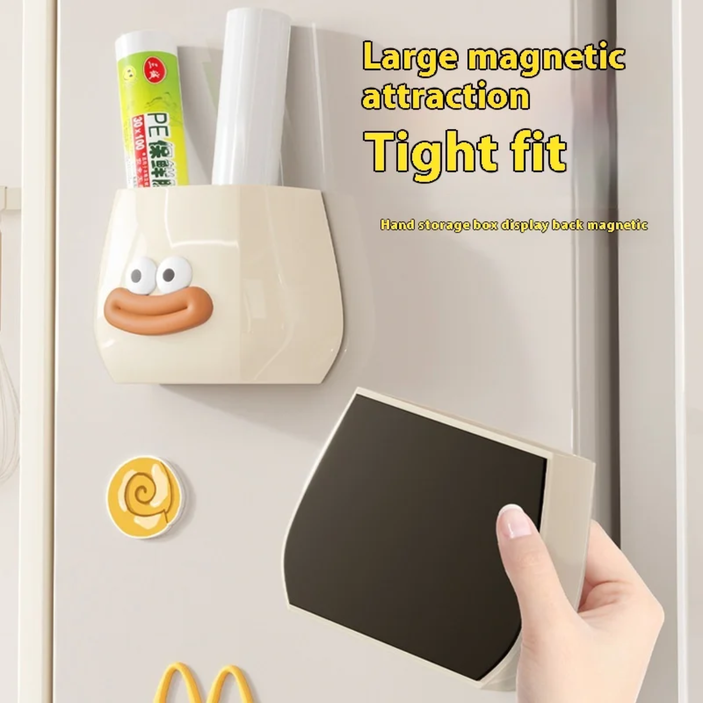 A cute cartoon-style wall-mounted organizer attached to a refrigerator, used to store plastic wraps or kitchen items while a person is holding it.
