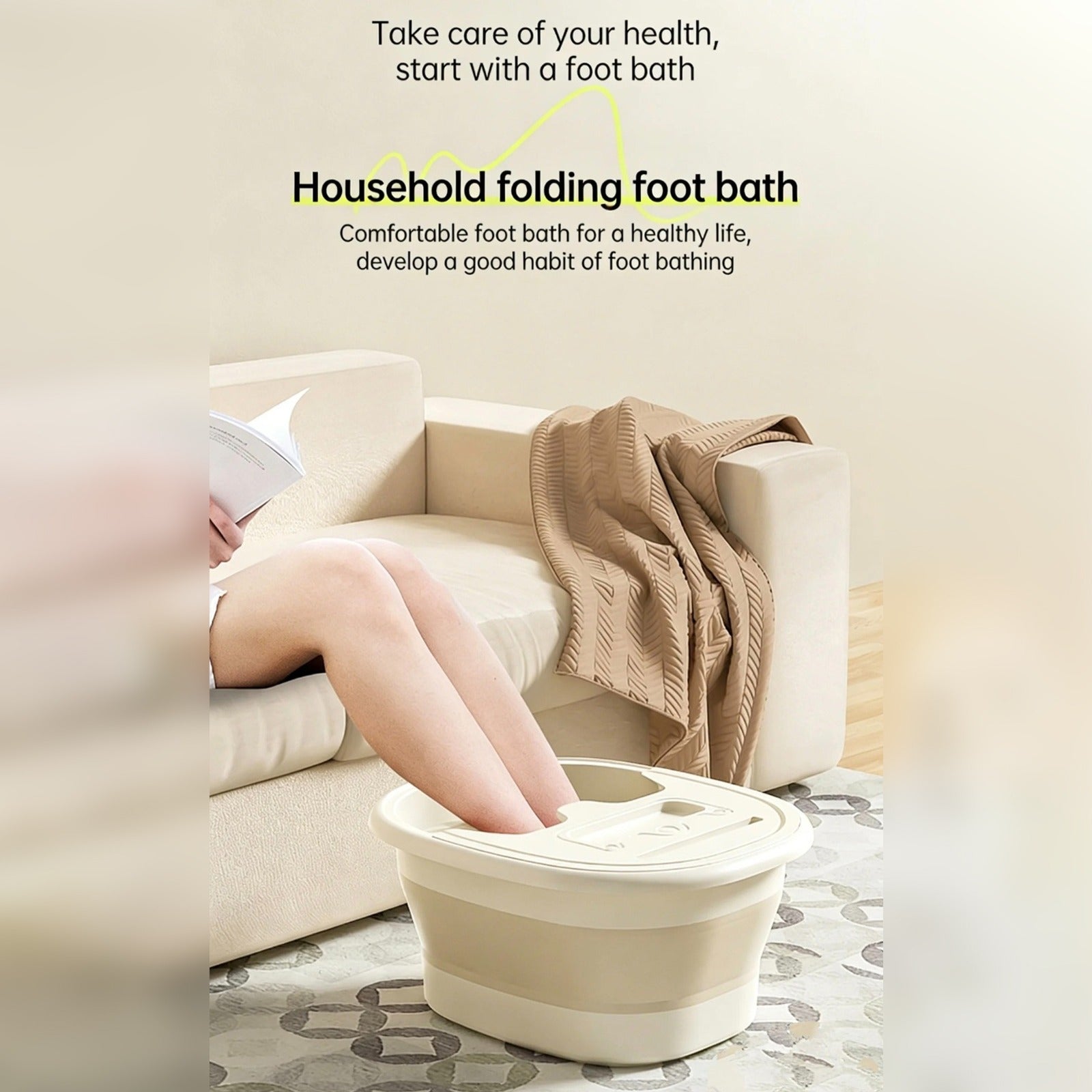 Person relaxing on a sofa with both feet soaking in a beige collapsible foot spa basin, placed on a patterned floor mat, promoting a comfortable household foot bath.