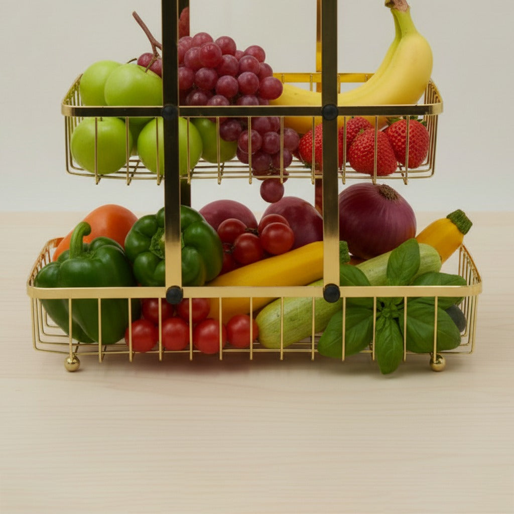 Gold three-tiered fruit and vegetable stand with various produce on a light background