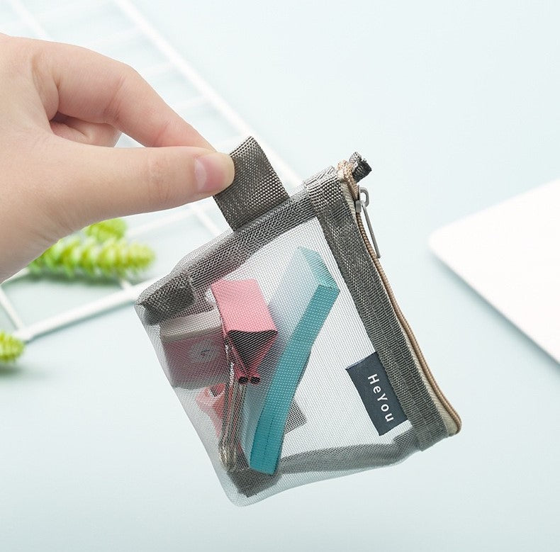 A person holding a Mini Zipper Pouch mesh bag, with a paper inside