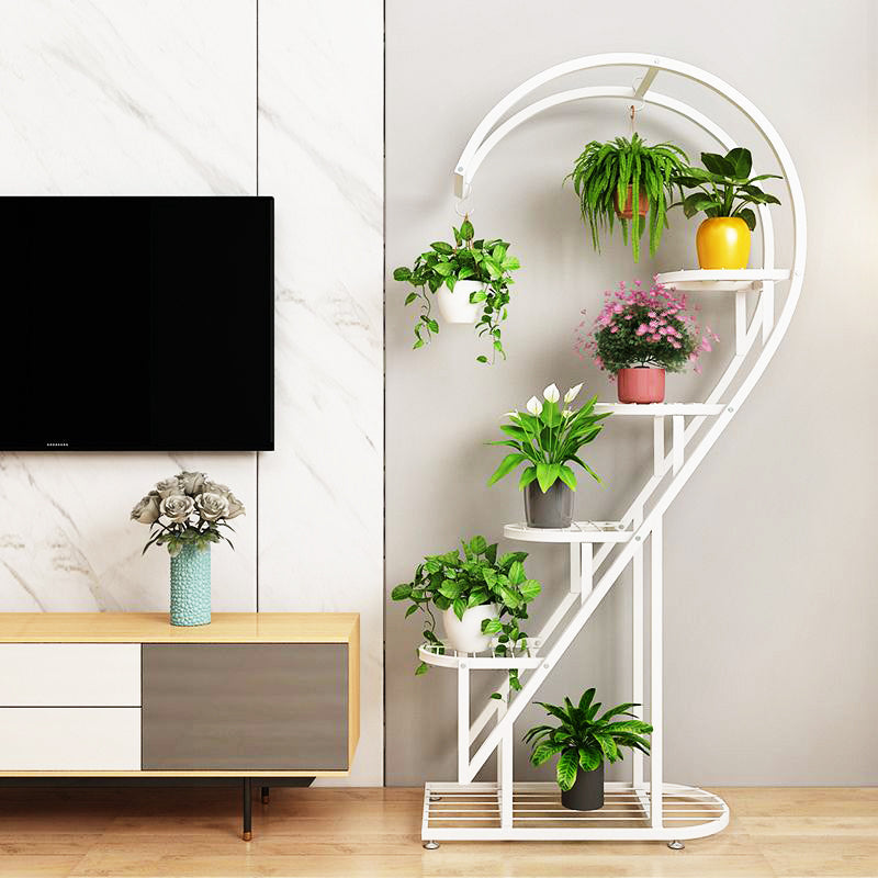 multi-tier plant stand with curved spiral design, featuring multiple shelves and hanging hooks displaying indoor potted plants and hanging planters.