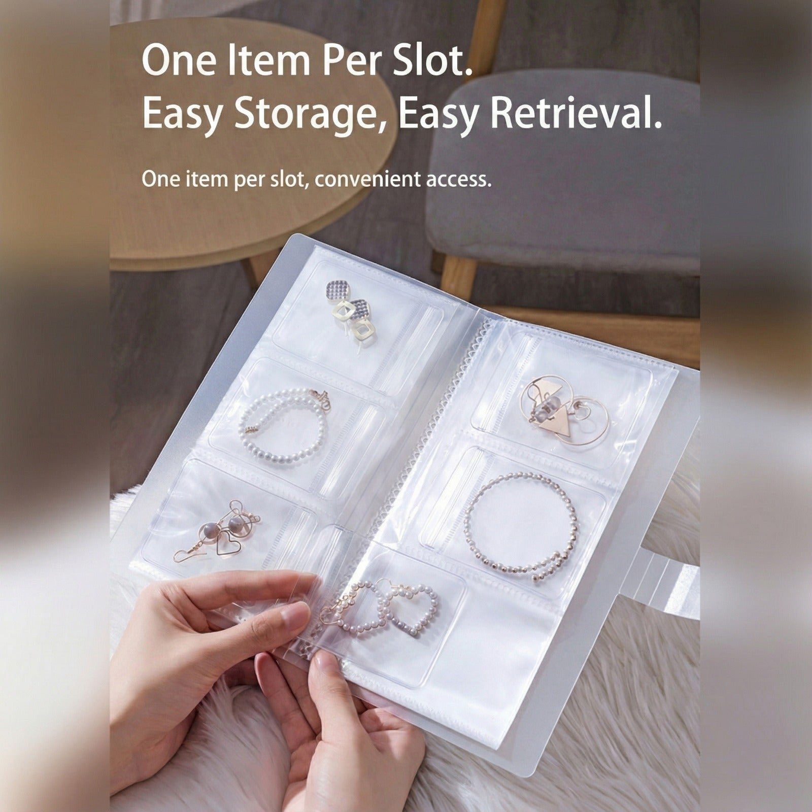 A person is holding transparent jewelry storage book with multiple clear pocket sleeves displaying neatly organized earrings, bracelets, and rings.