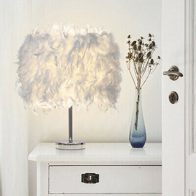A Feather Shade Table Lamp is placed on the table next to the vase