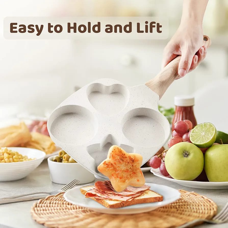 The person is holding a Non- Stick 4 Cup Egg Frying Pan,They’re carefully serving a star-shaped pancake
