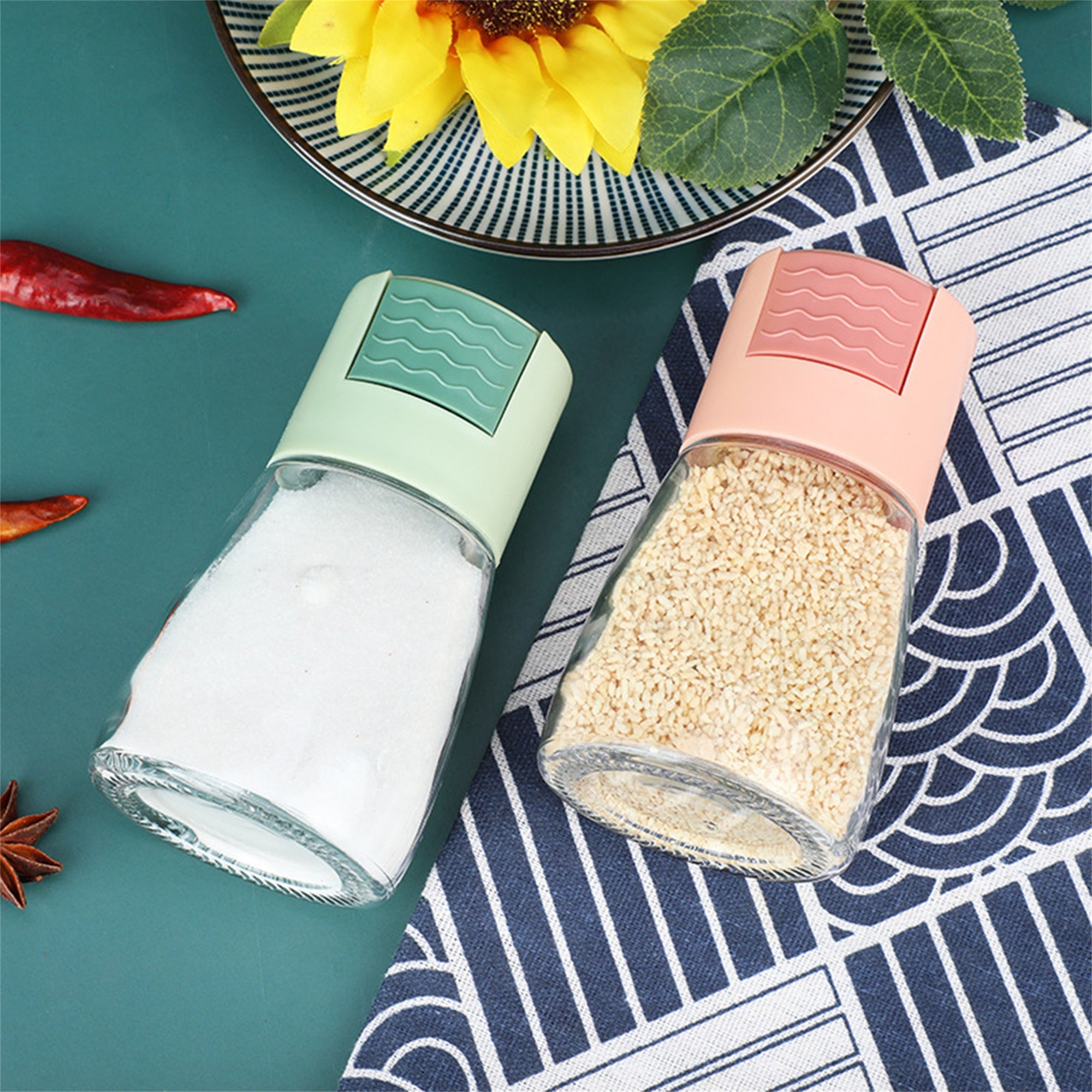 Measurable Mini Salt Control Bottle with Top Press Button placed next to chili