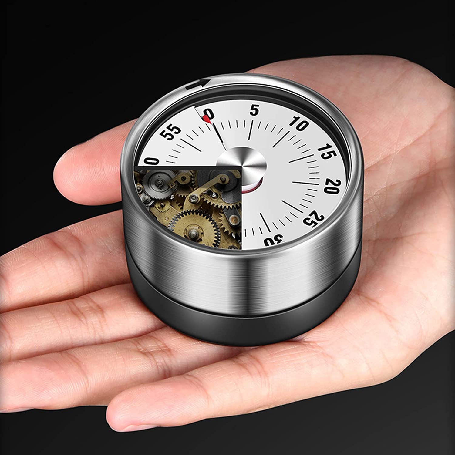 A hand holding a magnetic mechanical 60-minute timer