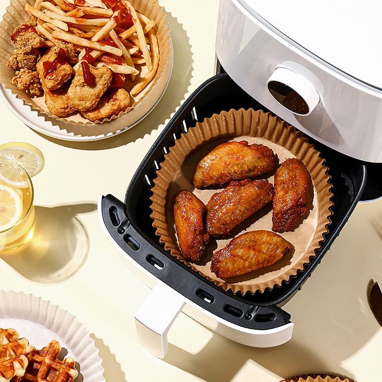 A group of disposable air fryer paper liners with food in them