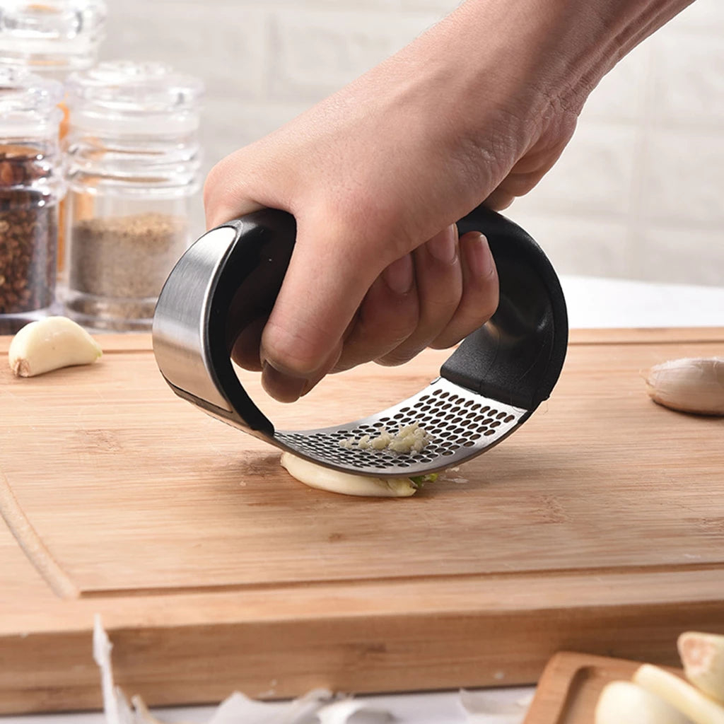 Someone using a Stainless Steel Garlic Press with a comfortable grip