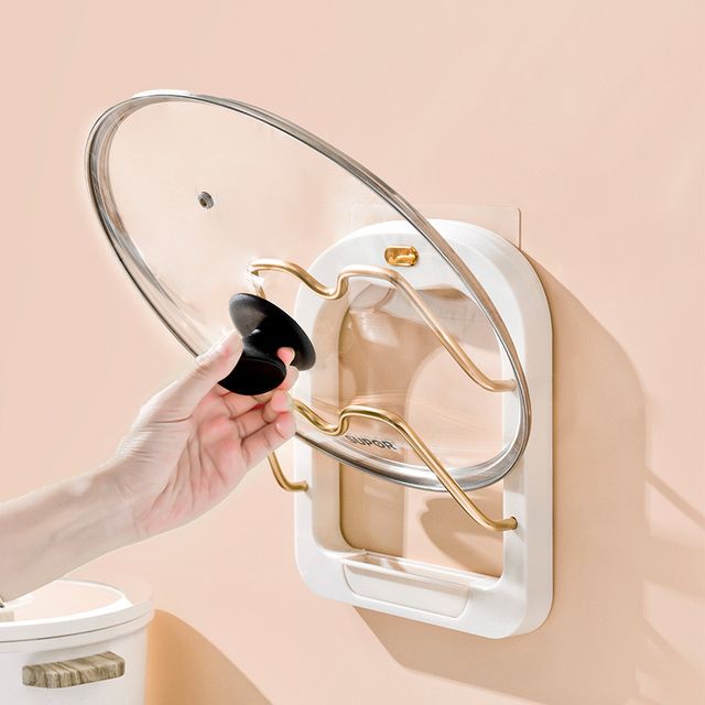 Someone is taking a pot lid from the Useful Kitchen 2 Tier Pot Lid Pan Holder Shelf