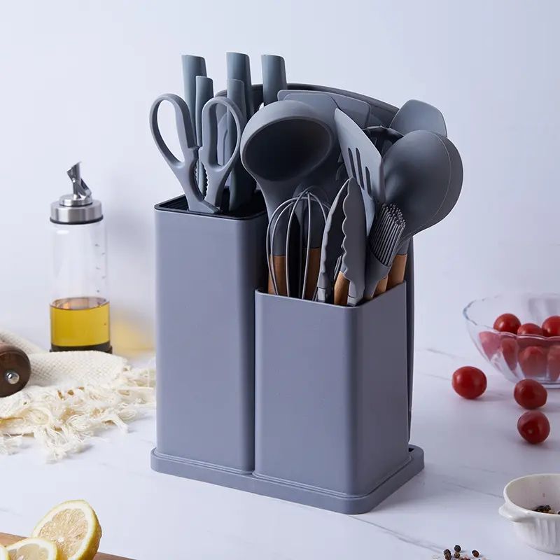 18-piece silicone kitchenware set in a  holder including spatulas, ladle, tongs, whisk, pasta server, brushes, and scissors, neatly organized on a kitchen countertop.