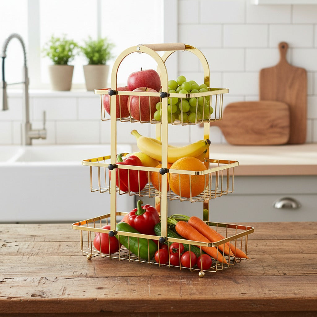 Three-tiered gold wire fruit and vegetable stand with fresh produce on a kitchen counter.