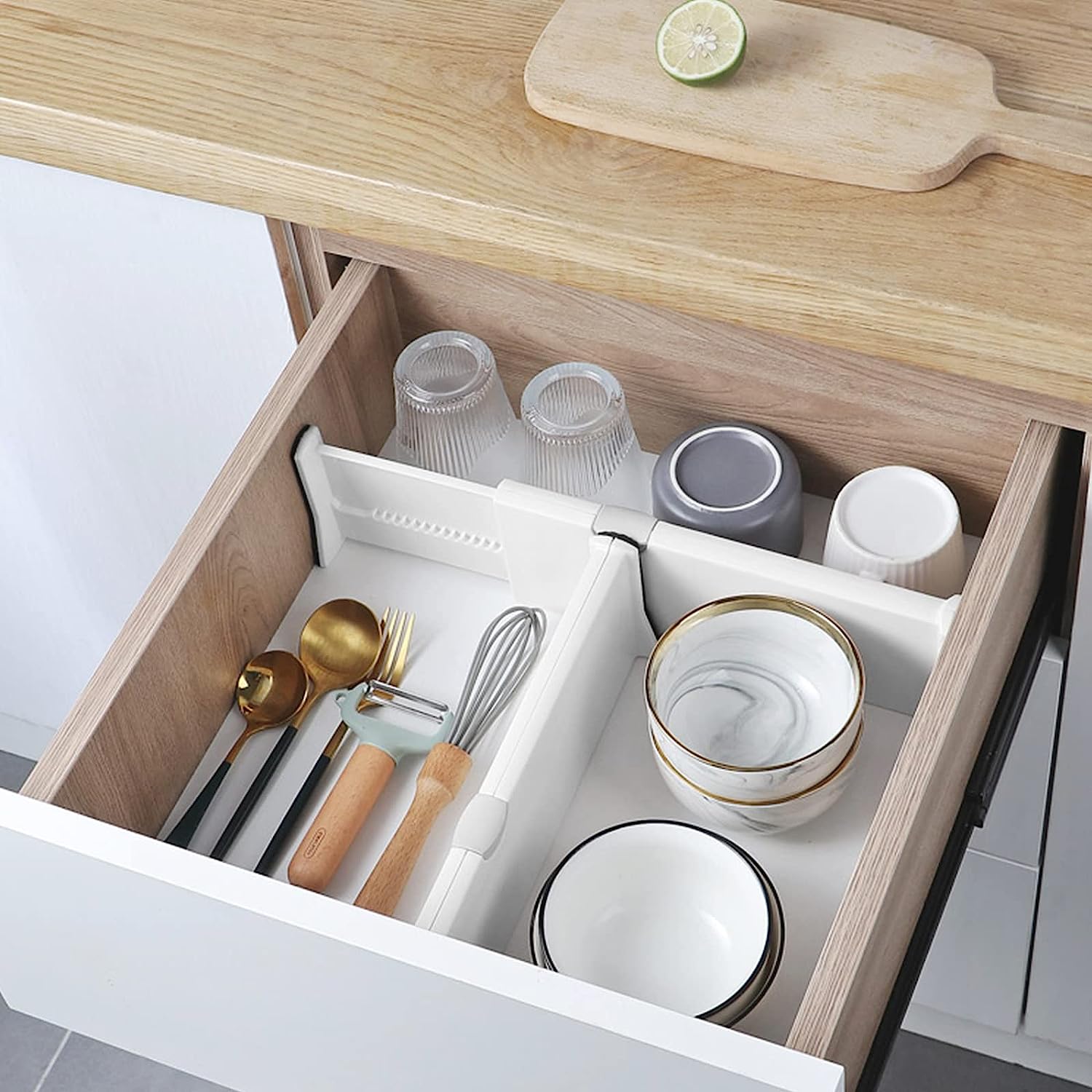 A drawer full of dishes and glasses separated with the help of drawer separator