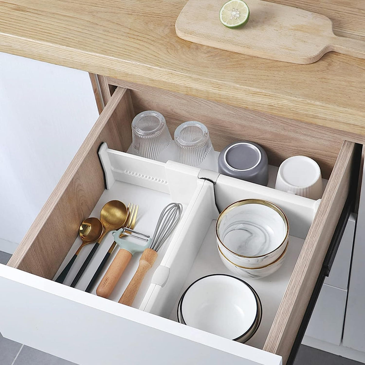 A drawer full of dishes and glasses separated with the help of drawer separator