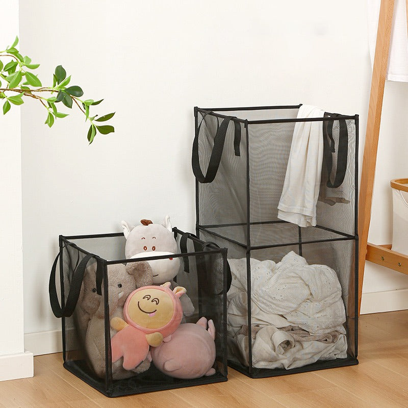 A black laundry hamper basket containing toys and a foldable laundry basket full of clothes.