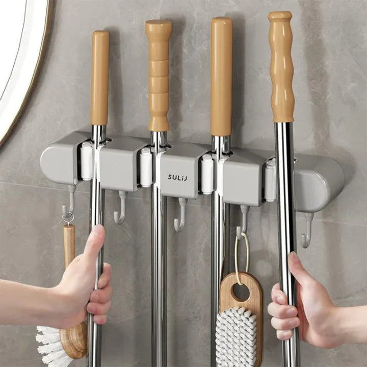A person Hanging mop in Wall-Mounted Mop Holder & Broom Hanger