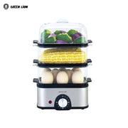 A 3-tier electric egg cooker and vegetable steamer with stacked transparent trays holding eggs, corn, and vegetables.